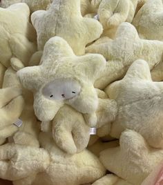 a pile of white teddy bears sitting next to each other on top of each other