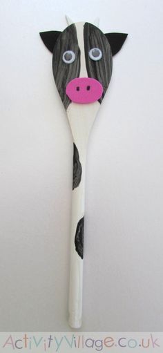 a black and white cow shaped toothbrush with pink nose