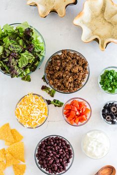 the ingredients to make this taco salad are laid out in bowls and ready to be eaten