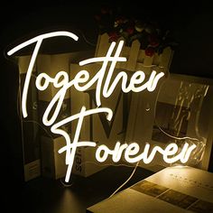 there is a neon sign that says together forever on the wall next to a book