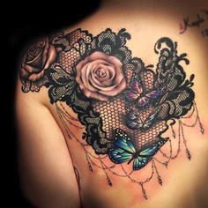 the back of a woman's shoulder with lace and roses on it, in black