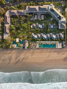 an aerial view of a beachfront resort and the ocean in front of it, taken from above