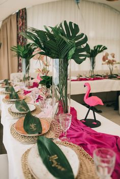 a table set with plates and place settings for a tropical themed party or bridal event