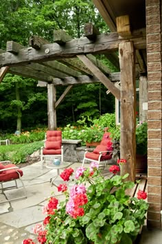 an outdoor patio with red chairs and flowers