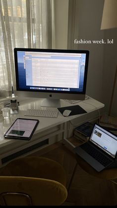 two laptops and a desktop computer sitting on a desk in front of a window