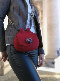 a woman is carrying a red purse on her back