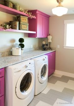 a washer and dryer in a room with pink cabinets