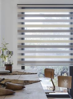 a table with some shoes on it next to a window covered in shades and blinds