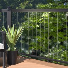 a potted plant sitting on top of a wooden deck next to a chair and table