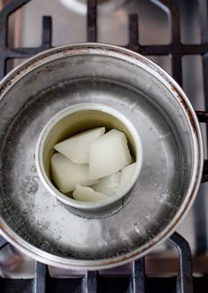 there is ice cubes in the bottom of a pot on an oven burner