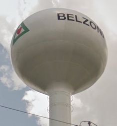 a large white water tower with the word belzon written on it's side