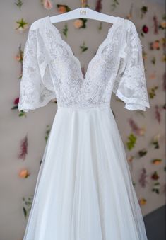 a white wedding dress hanging on a hanger