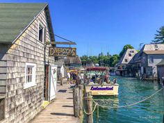 a boat is docked at the dock in front of some buildings and people on it