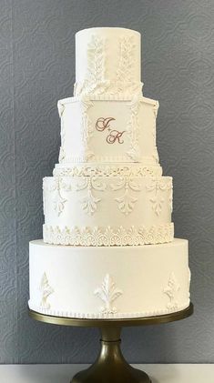 a three tiered white wedding cake sitting on top of a table