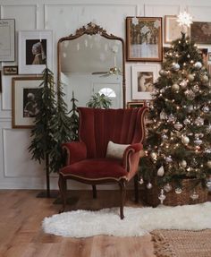 a living room with a christmas tree in the corner and pictures on the wall behind it