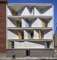 an apartment building with multi - colored shutters on the front and side windows that are open