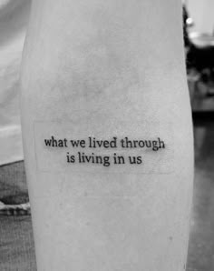 a person with a tattoo on their leg that says, what we lived through is living in us