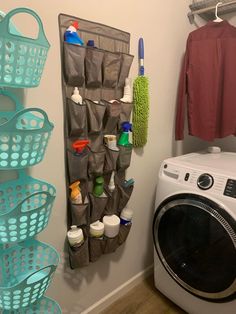 a washer and dryer in a bathroom next to a drying rack with cleaning products on it