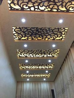 the ceiling in this room is decorated with intricate designs and lights on it's sides