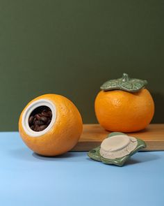 two oranges sitting next to each other on a wooden cutting board with seeds in the middle