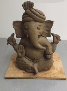 an elephant statue sitting on top of a wooden board