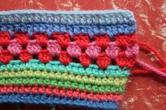 a colorful crocheted bag sitting on top of a table