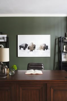 a desk with a book on it in front of a painting