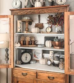 a wooden cabinet filled with lots of different types of clocks on top of each shelf