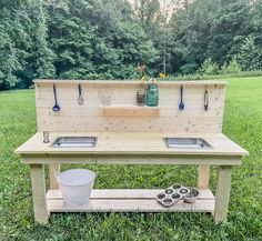 an outdoor kitchen made out of pallet wood with two sinks and utensils