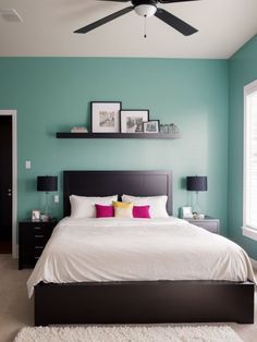 a bedroom with blue walls and white bedding, black headboard, and ceiling fan