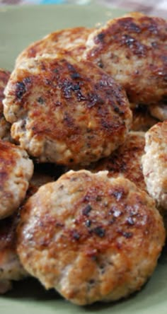 several hamburger patties on a green plate