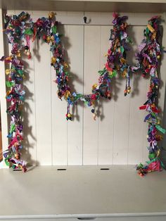 the letter h is made out of colorful origami pieces and hangs on a white wall