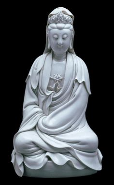 a white buddha statue sitting on top of a table