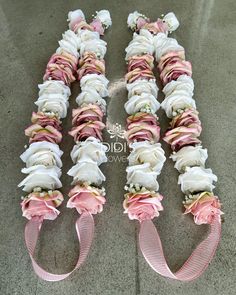 pink and white flowers are arranged in rows on the floor