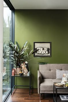 a living room with green walls and wooden floors