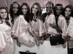 a group of women standing next to each other in pink robes and matching purses