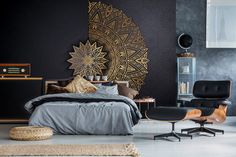 a bedroom with a bed, chair and ottoman in black and gold colors on the wall