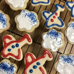 decorated cookies on a cooling rack with blue, white and red icing in the middle