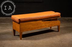 a wooden bench with a leather seat on it