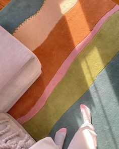 a person is laying on the floor with their feet propped up in front of an area rug