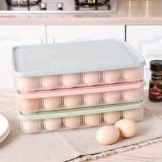 three plastic containers filled with eggs sitting on top of a counter next to an oven