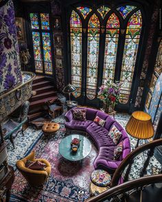 a living room filled with furniture and stained glass windows