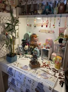 a cluttered kitchen counter with lots of stuff on it and a potted plant in the corner