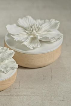 two white flower shaped dishes sitting on top of a table