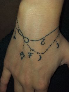 a woman's hand with a tattoo on it and an infinite knot around the wrist