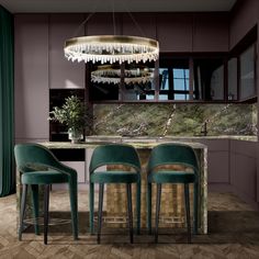 three green chairs sitting in front of a marble counter top with a chandelier hanging from the ceiling