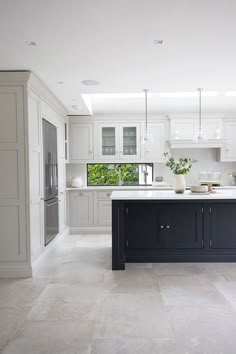 a large kitchen with white cabinets and black island