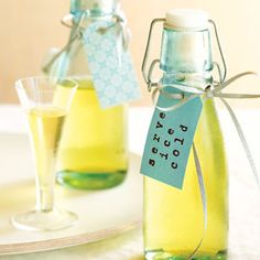 two glass bottles with labels on them sitting next to each other, one filled with liquid and the other empty