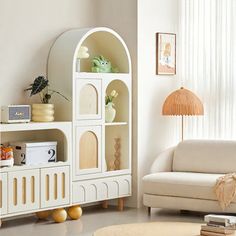 a living room filled with furniture and a white bookcase in front of a window