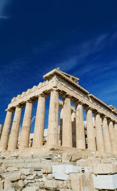 an ancient greek temple on top of a rocky hill with blue skies in the background